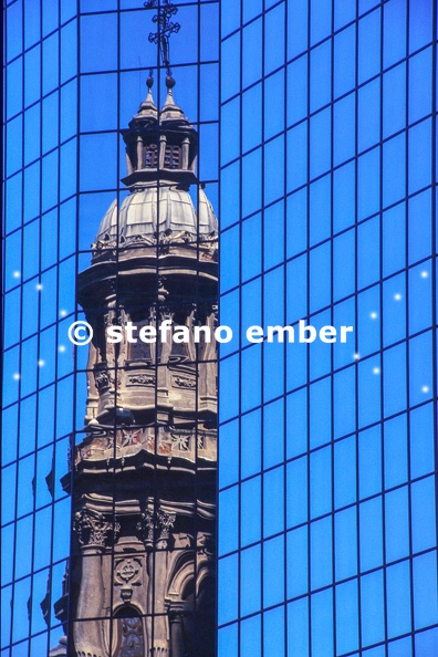 Reflection of the cathedral bell tower in a modern building at Santiago