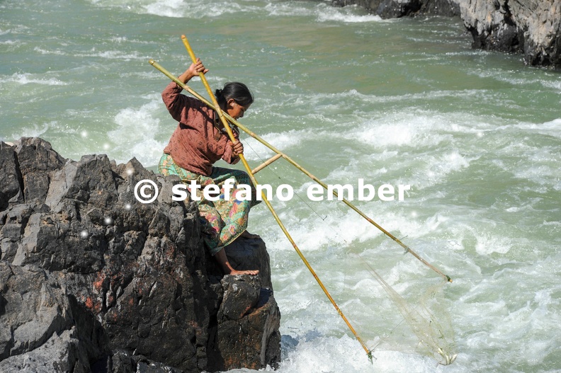 Woman fishing with a rudimentary network in the Mekong river at Don Khon island