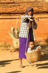 Woman with her son on a basket at the archaeological site of Bagan