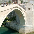 Tourists watching at people who jump from the famous bridge of Mostar