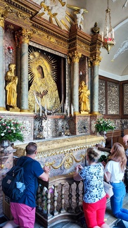 People praying at the black madonna on gate of dawn chapel at Vilnius