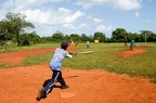 Boys playing baseball on a field at Las Galeras