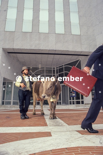 Proud_farmer_with_his_cow_in_front_of_a_bank_and_businessman_holding_briefcase.jpg