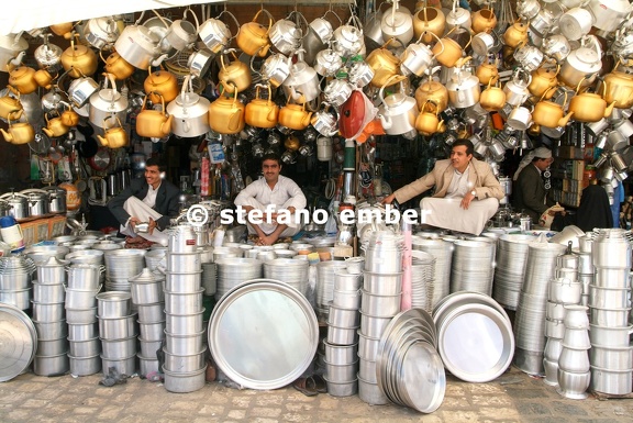 People selling teapots and plates on the market of Sana